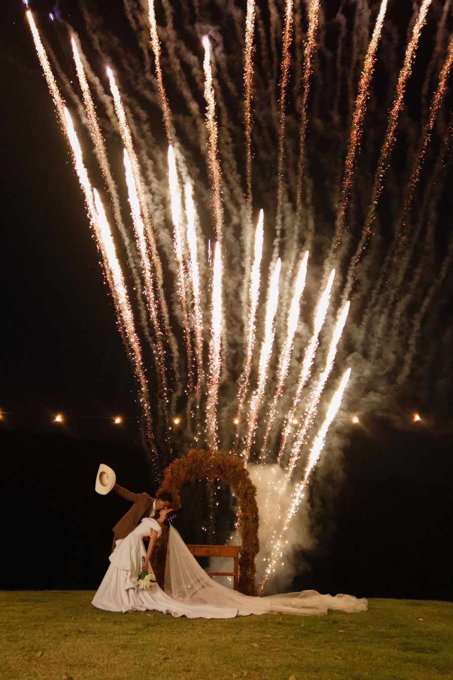 Noivos se beijando sob fogos de artifício